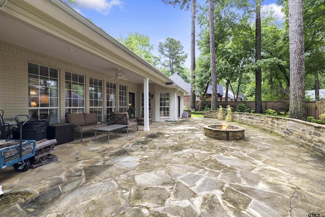 view of patio / terrace featuring a fenced backyard, ceiling fan, and an outdoor living space with a fire pit