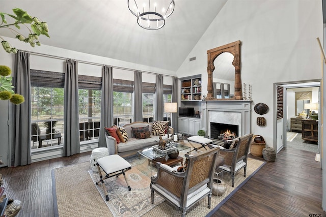 living room featuring visible vents, a fireplace, wood finished floors, high vaulted ceiling, and an inviting chandelier