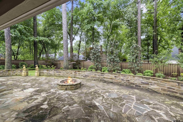 view of patio featuring a fenced backyard and an outdoor fire pit