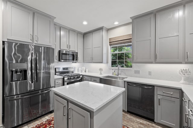kitchen with a sink, a center island, stainless steel appliances, recessed lighting, and gray cabinetry