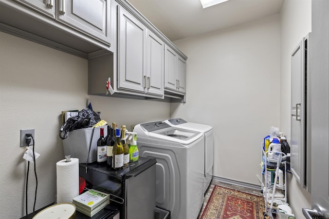 laundry area with baseboards, cabinet space, and washing machine and dryer