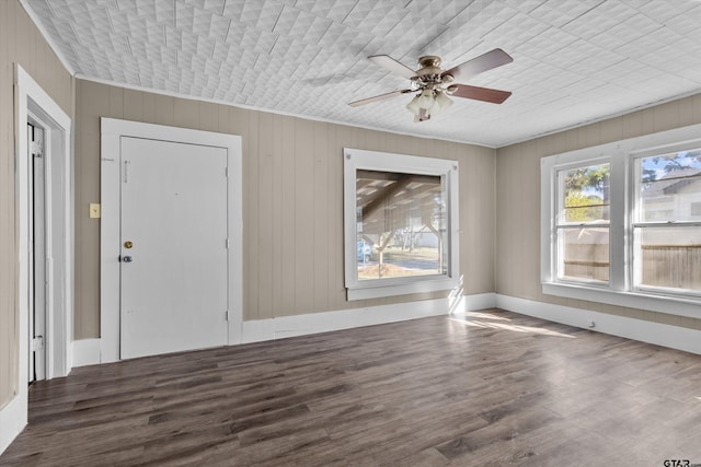 foyer featuring ornamental molding, ceiling fan, wooden walls, and dark hardwood / wood-style floors