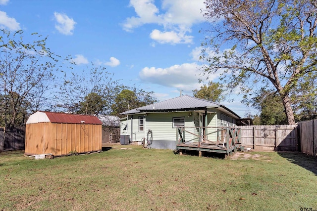 rear view of house with a lawn and a storage shed