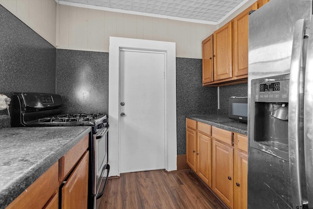 kitchen featuring ornamental molding, stainless steel appliances, and dark hardwood / wood-style flooring