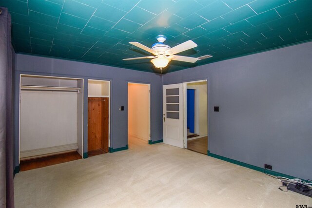 unfurnished bedroom featuring light carpet, ceiling fan, and a closet