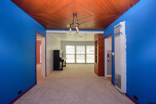 hallway with light colored carpet, wood ceiling, and crown molding