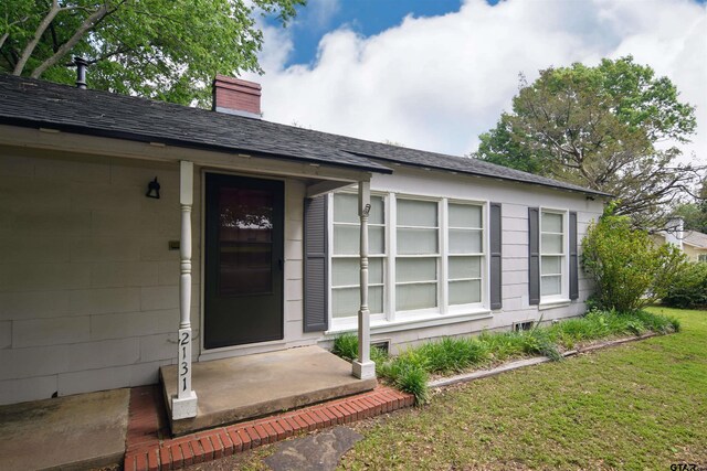 view of exterior entry featuring a yard