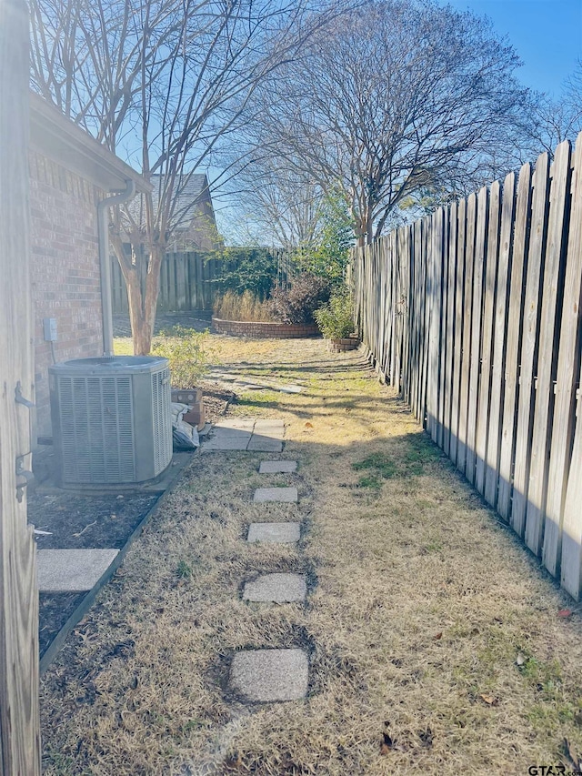 view of yard with central AC and a fenced backyard