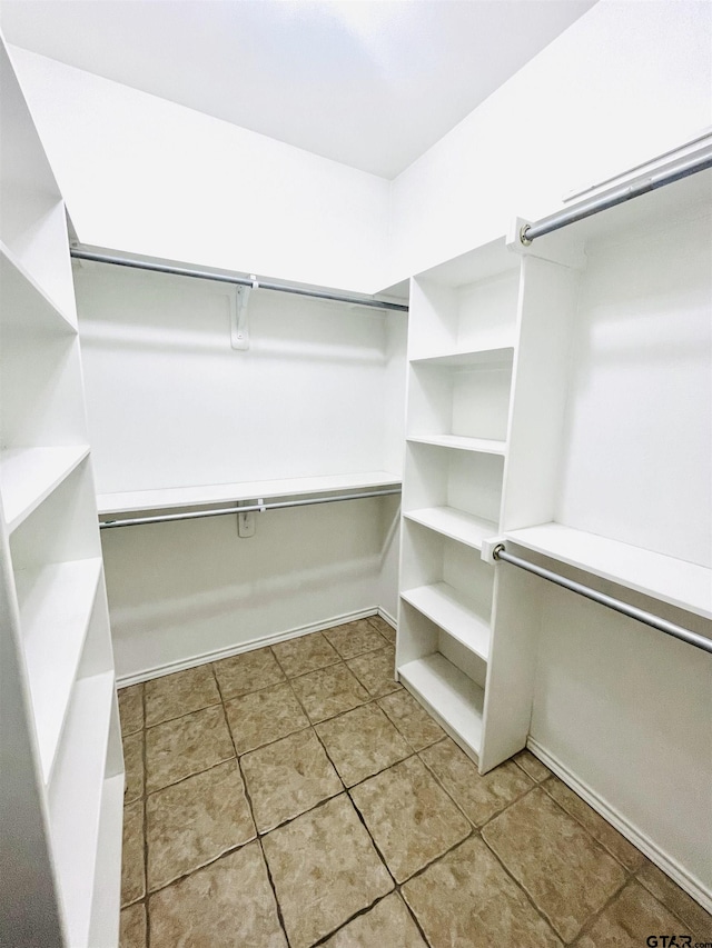 walk in closet with light tile patterned floors