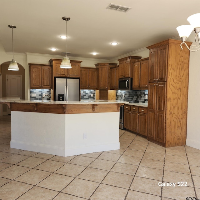 kitchen featuring visible vents, a spacious island, appliances with stainless steel finishes, hanging light fixtures, and light countertops