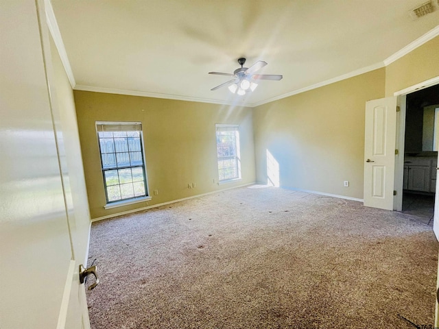 unfurnished room featuring ornamental molding, carpet, visible vents, and baseboards