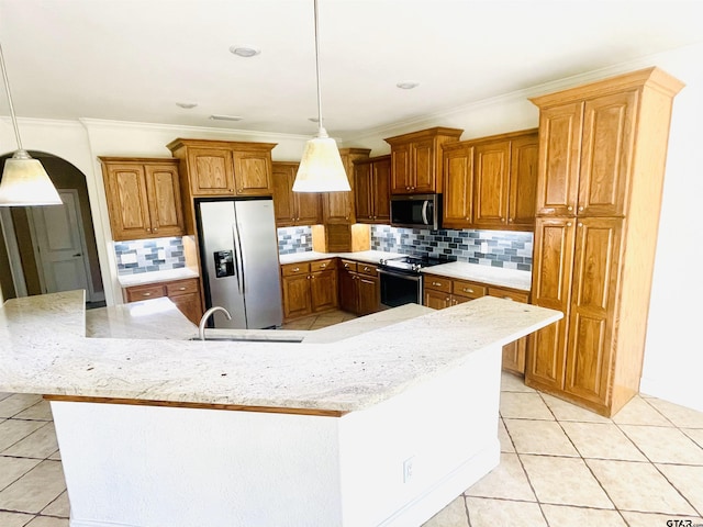 kitchen featuring hanging light fixtures, arched walkways, stainless steel appliances, and a large island with sink