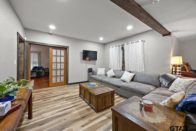 living room featuring light wood-type flooring, beamed ceiling, baseboards, and recessed lighting