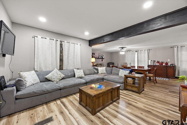 living room with light wood finished floors, beam ceiling, visible vents, and recessed lighting