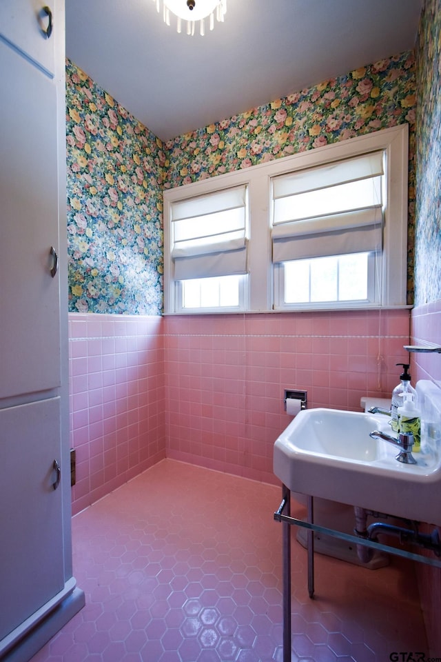 510 E Longview St, Arp, TX 75750 - bathroom with wallpapered walls, a wainscoted wall, tile patterned floors, tile walls, and a sink