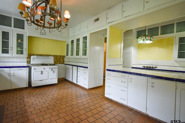 510 E Longview St, Arp, TX 75750 - kitchen with tile counters, a chandelier, backsplash, gas stove, and brick patterned flooring