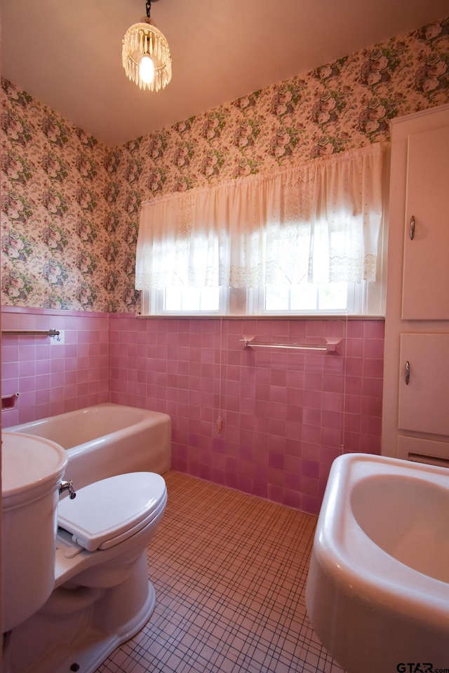 510 E Longview St, Arp, TX 75750 - bathroom featuring wallpapered walls, plenty of natural light, tile walls, toilet, and wainscoting