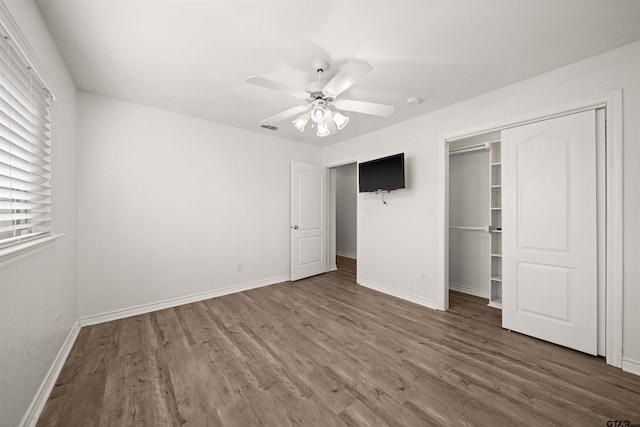 unfurnished bedroom with ceiling fan, a closet, and dark hardwood / wood-style flooring