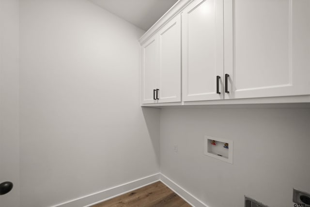 laundry area with cabinets, electric dryer hookup, dark hardwood / wood-style floors, and hookup for a washing machine