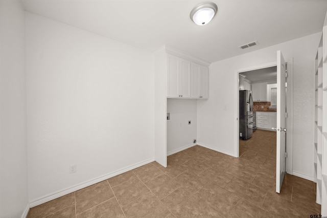 laundry area with hookup for an electric dryer, hookup for a washing machine, and cabinets