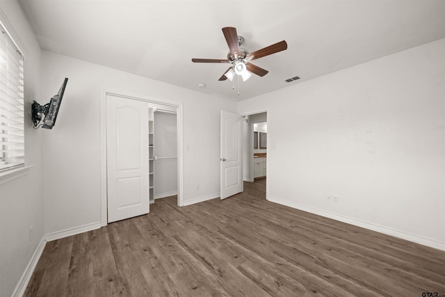 unfurnished bedroom featuring ceiling fan, a closet, and dark hardwood / wood-style floors