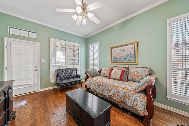 living area with baseboards, wood finished floors, a ceiling fan, and ornamental molding