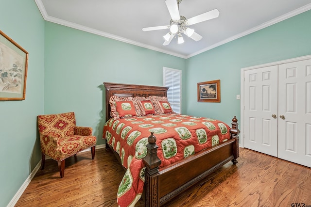 bedroom with crown molding, baseboards, wood finished floors, a closet, and a ceiling fan