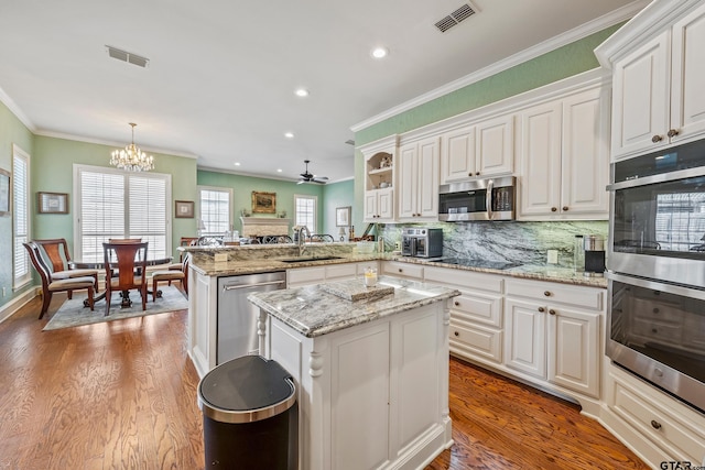 kitchen featuring a sink, a peninsula, visible vents, and stainless steel appliances