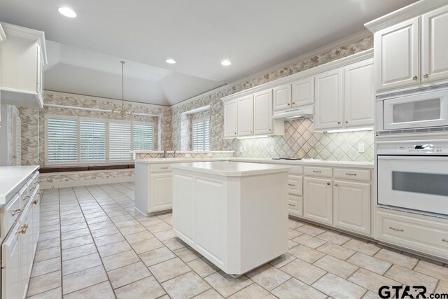 6529 Salisbury Ln, Tyler, TX 75703 - kitchen with a center island, white appliances, white cabinets, and light countertops