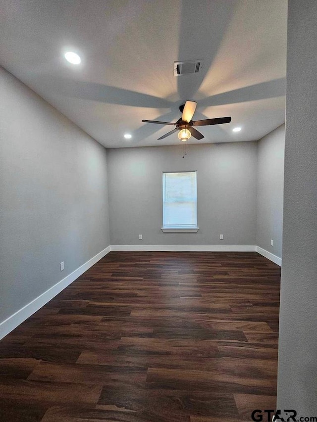 spare room featuring ceiling fan and dark wood-type flooring