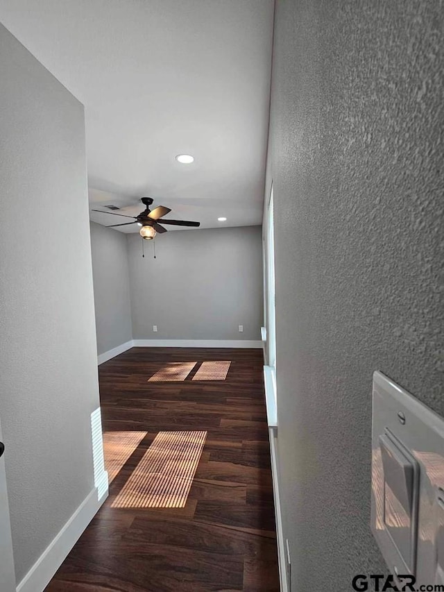 spare room featuring ceiling fan and dark wood-type flooring