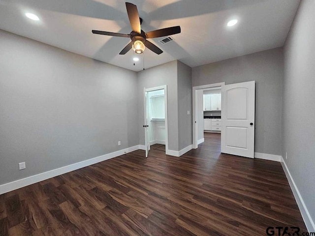 unfurnished bedroom with dark hardwood / wood-style floors, ceiling fan, and a walk in closet