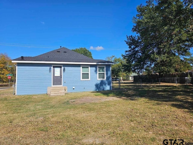 rear view of property featuring a yard