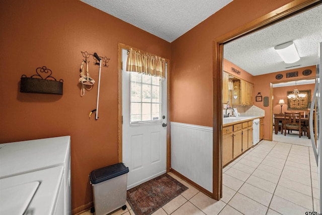 812 Jeffery Dr, Tyler, TX 75703 - entryway featuring a textured ceiling, a chandelier, a wainscoted wall, and light tile patterned floors