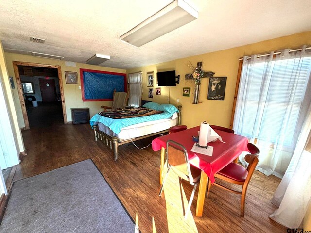 bedroom featuring a textured ceiling and dark hardwood / wood-style floors