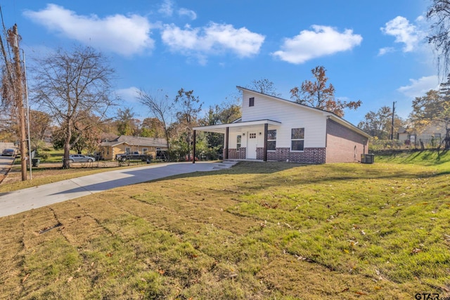 1410 W Connally St, Tyler, TX 75701 - view of front of home with brick siding, driveway, a porch, an attached carport, and a front yard
