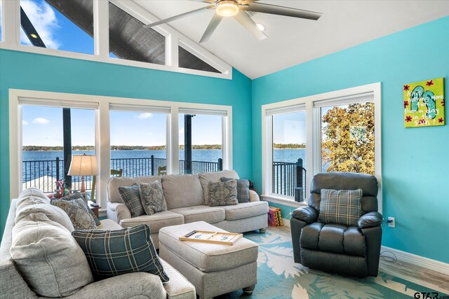 living area featuring wood finished floors, a water view, baseboards, high vaulted ceiling, and a ceiling fan