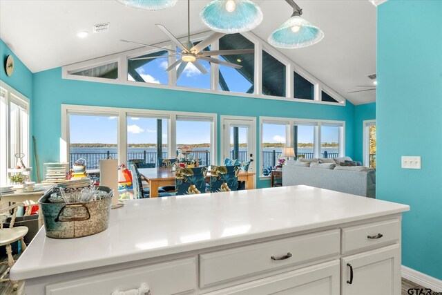 kitchen featuring a ceiling fan, visible vents, white cabinets, and plenty of natural light