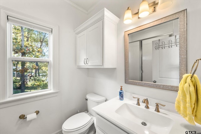 bathroom featuring vanity, toilet, ornamental molding, and an enclosed shower