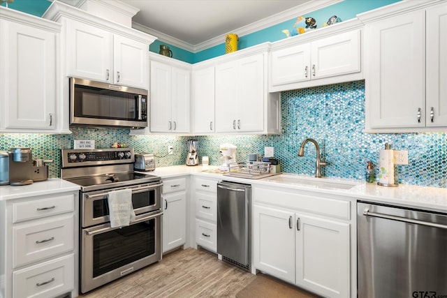 kitchen with appliances with stainless steel finishes, light countertops, and a sink