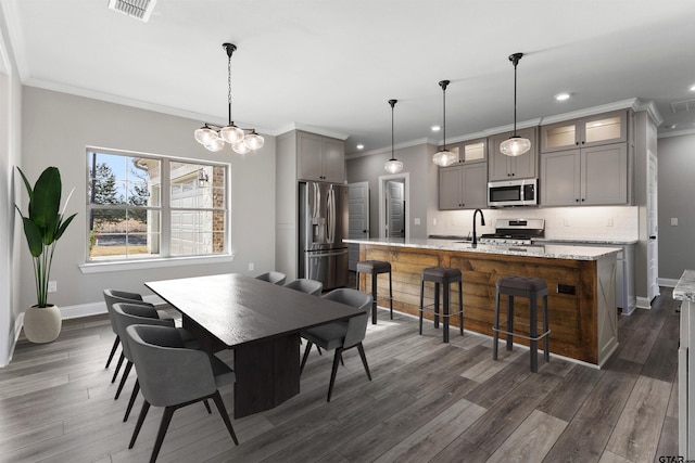 dining area with ornamental molding, dark hardwood / wood-style flooring, and a notable chandelier