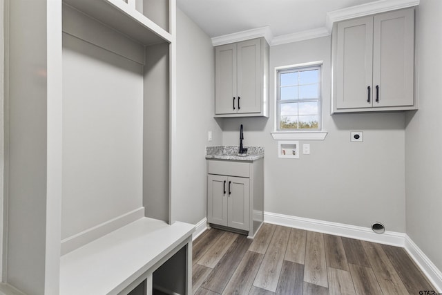 laundry area featuring dark wood-type flooring, cabinets, hookup for a washing machine, hookup for an electric dryer, and crown molding