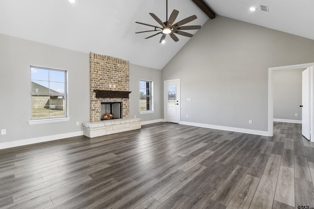 unfurnished living room with a brick fireplace, dark hardwood / wood-style flooring, and ceiling fan