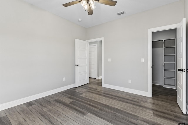 unfurnished bedroom featuring ceiling fan, dark hardwood / wood-style floors, and a closet