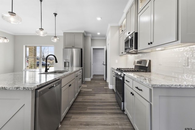 kitchen with stainless steel appliances, tasteful backsplash, decorative light fixtures, light stone countertops, and sink