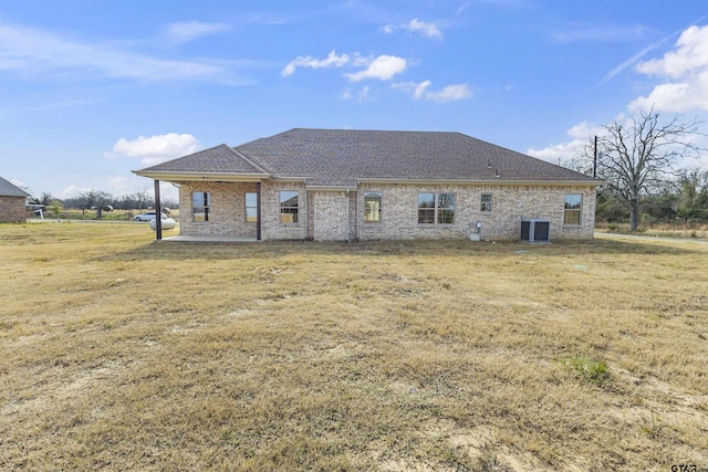 rear view of property featuring a lawn, cooling unit, and a patio