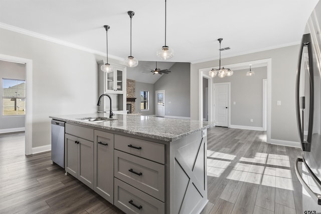 kitchen with a center island with sink, gray cabinets, appliances with stainless steel finishes, lofted ceiling, and sink