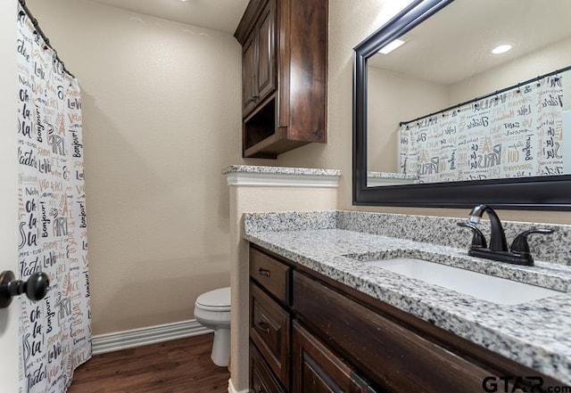 706 Duke Pl, Tyler, TX 75704 - bathroom featuring toilet, vanity, wood finished floors, baseboards, and a shower with curtain