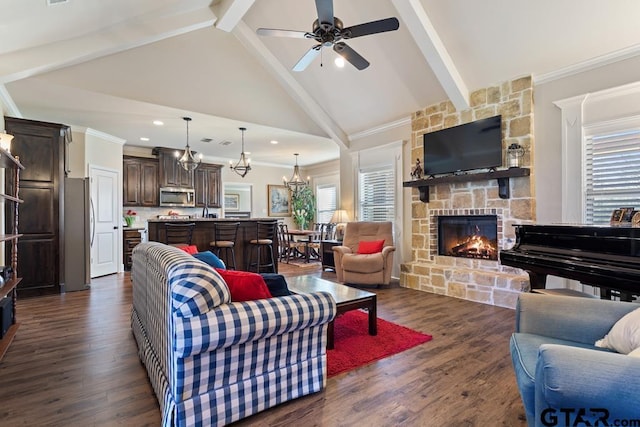 706 Duke Pl, Tyler, TX 75704 - living room featuring a fireplace, beamed ceiling, ceiling fan, a chandelier, and dark wood-style floors