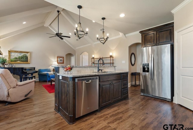 706 Duke Pl, Tyler, TX 75704 - kitchen with appliances with stainless steel finishes, a sink, arched walkways, open floor plan, and dark brown cabinets
